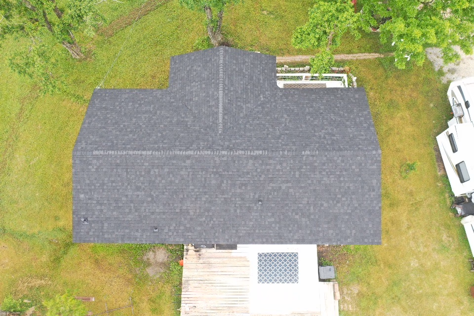 The same home after roof replacement with new charcoal architectural shingles installed edge to edge in Austin, TX