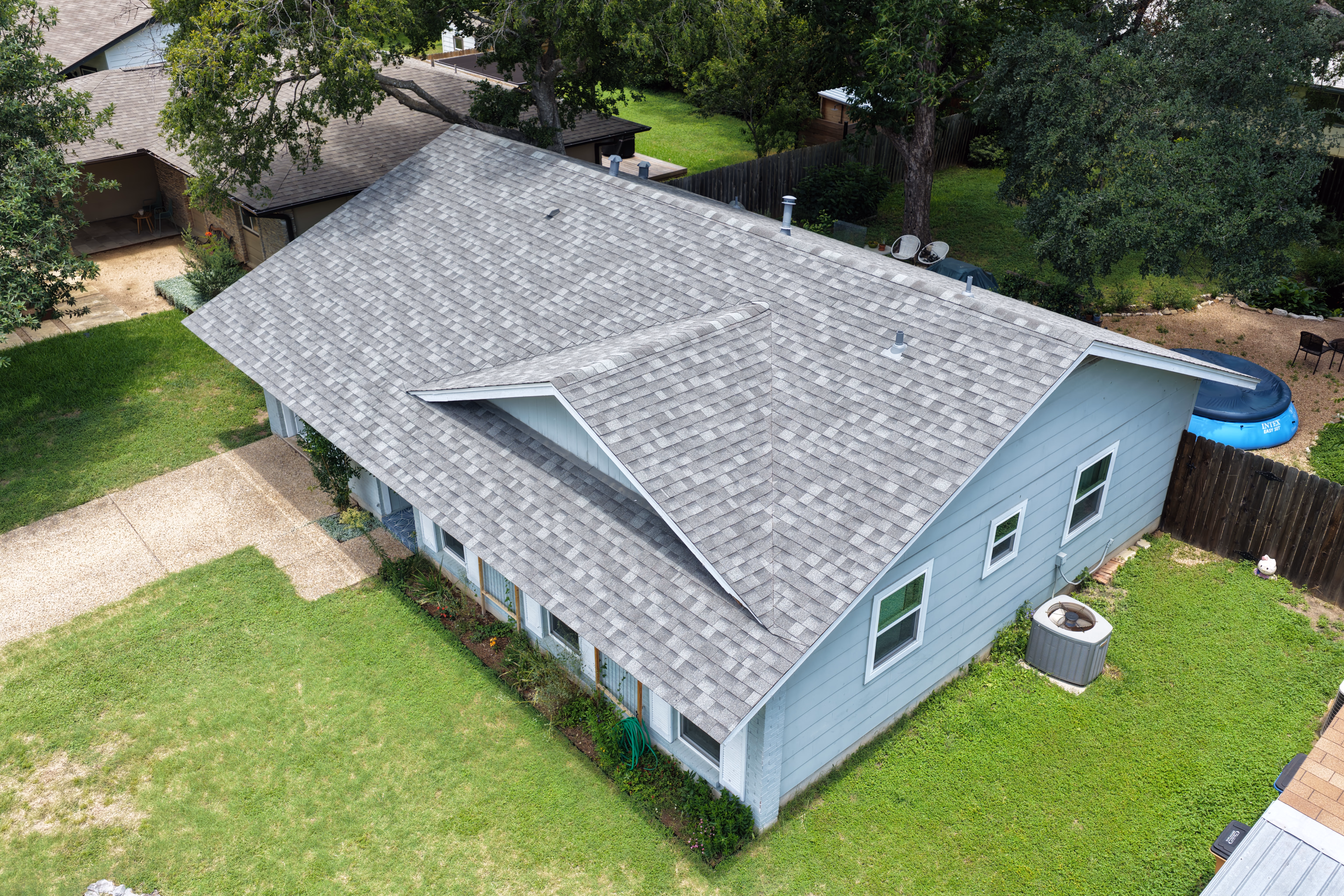 Aerial drone view of a gray architectural asphalt shingle roof installed on a home in Austin, TX