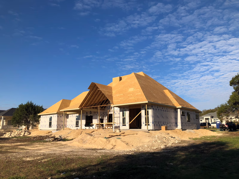 New construction home with bare OSB roof decking ready for underlayment during a roof installation in Austin, TX