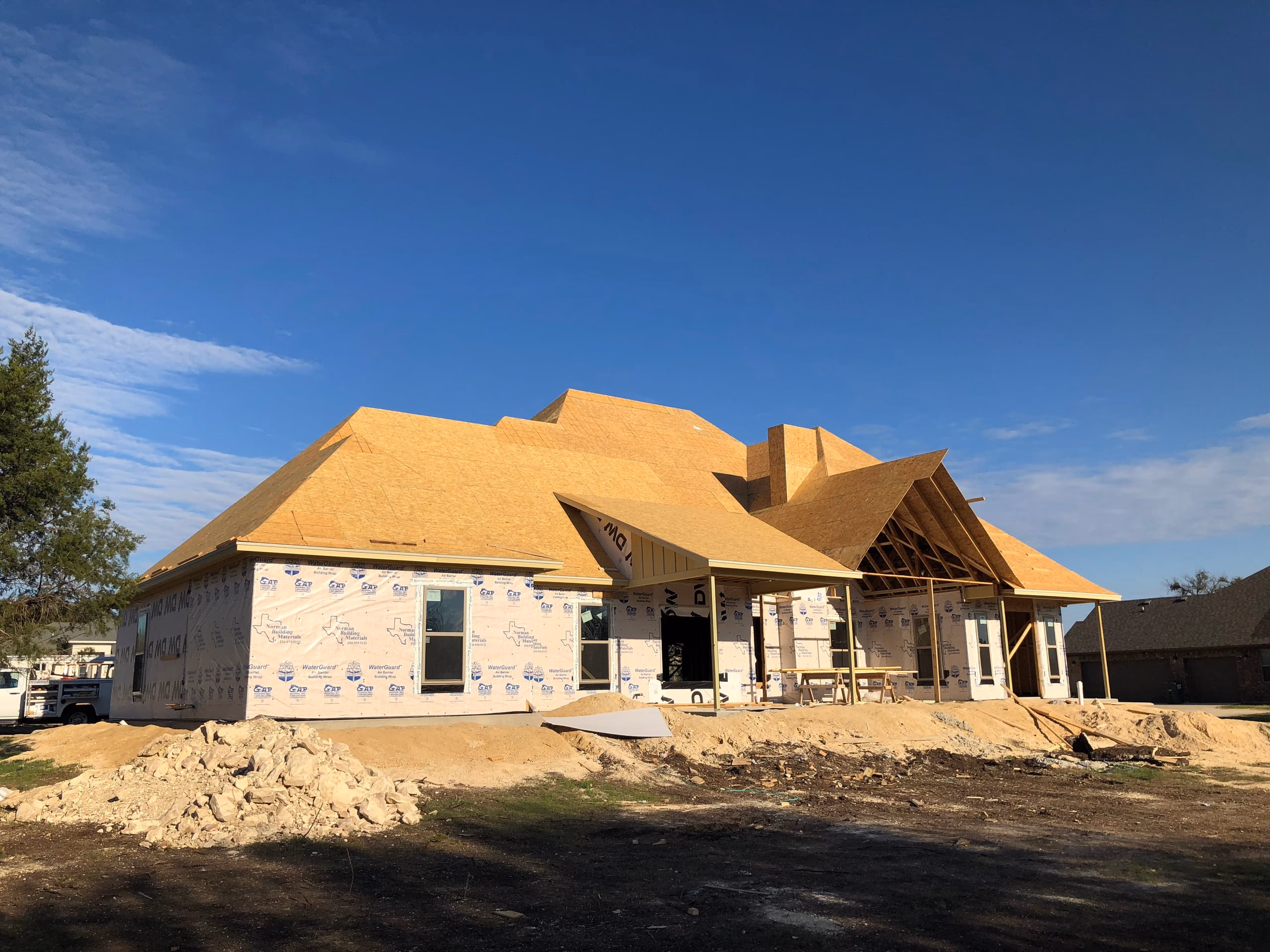 New construction home fully decked in OSB with housewrap on the walls and no roofing installed yet in Austin, TX