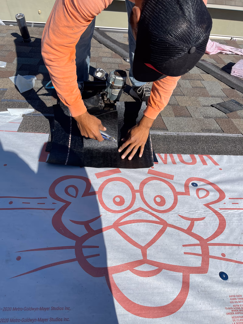Austin Roofing Company crew member cutting in a shingle repair over Owens Corning synthetic underlayment on an Austin, TX roof