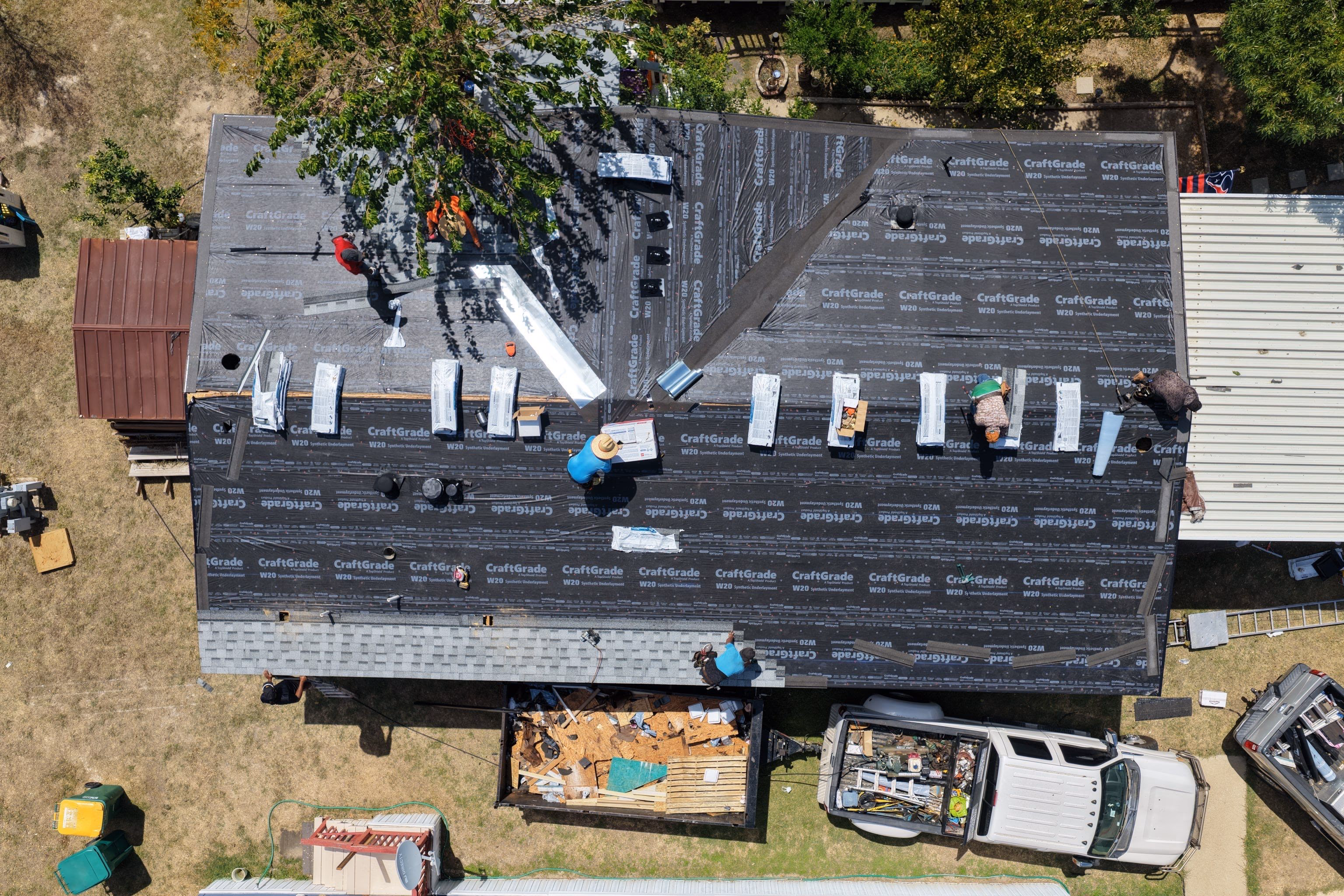 Shingle bundles staged across a roof with synthetic underlayment fully installed in Austin, TX