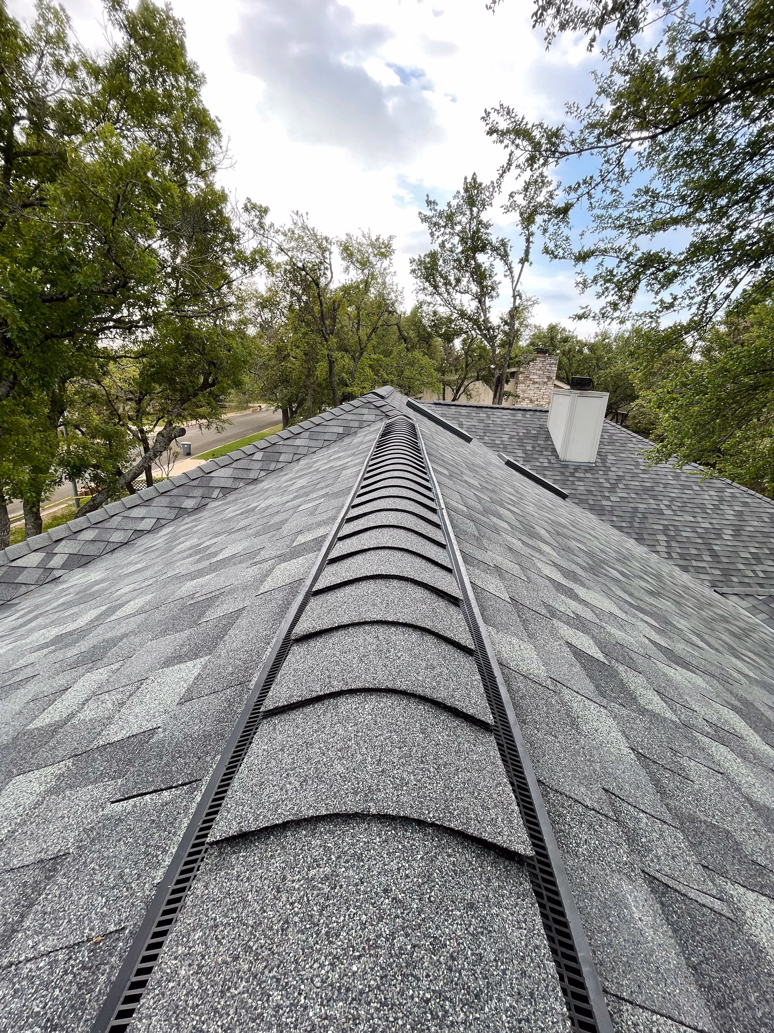 Ridge vent detail on a completed architectural shingle roof in Austin TX