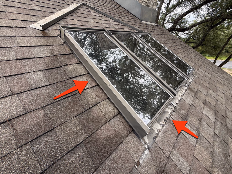 Roof leak diagnosis in Austin, TX: failed and corroded skylight flashing marked for repair on an asphalt shingle roof by Austin Roofing Company