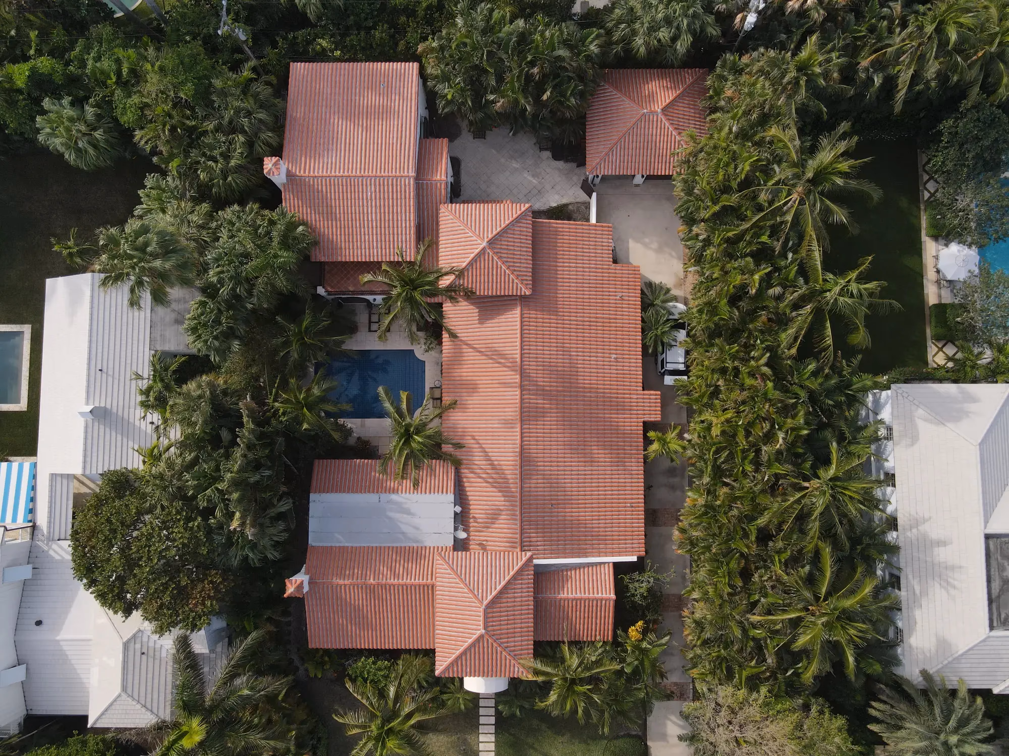 Aerial drone view of a terracotta Spanish barrel clay tile roof installed on a Mediterranean-style home