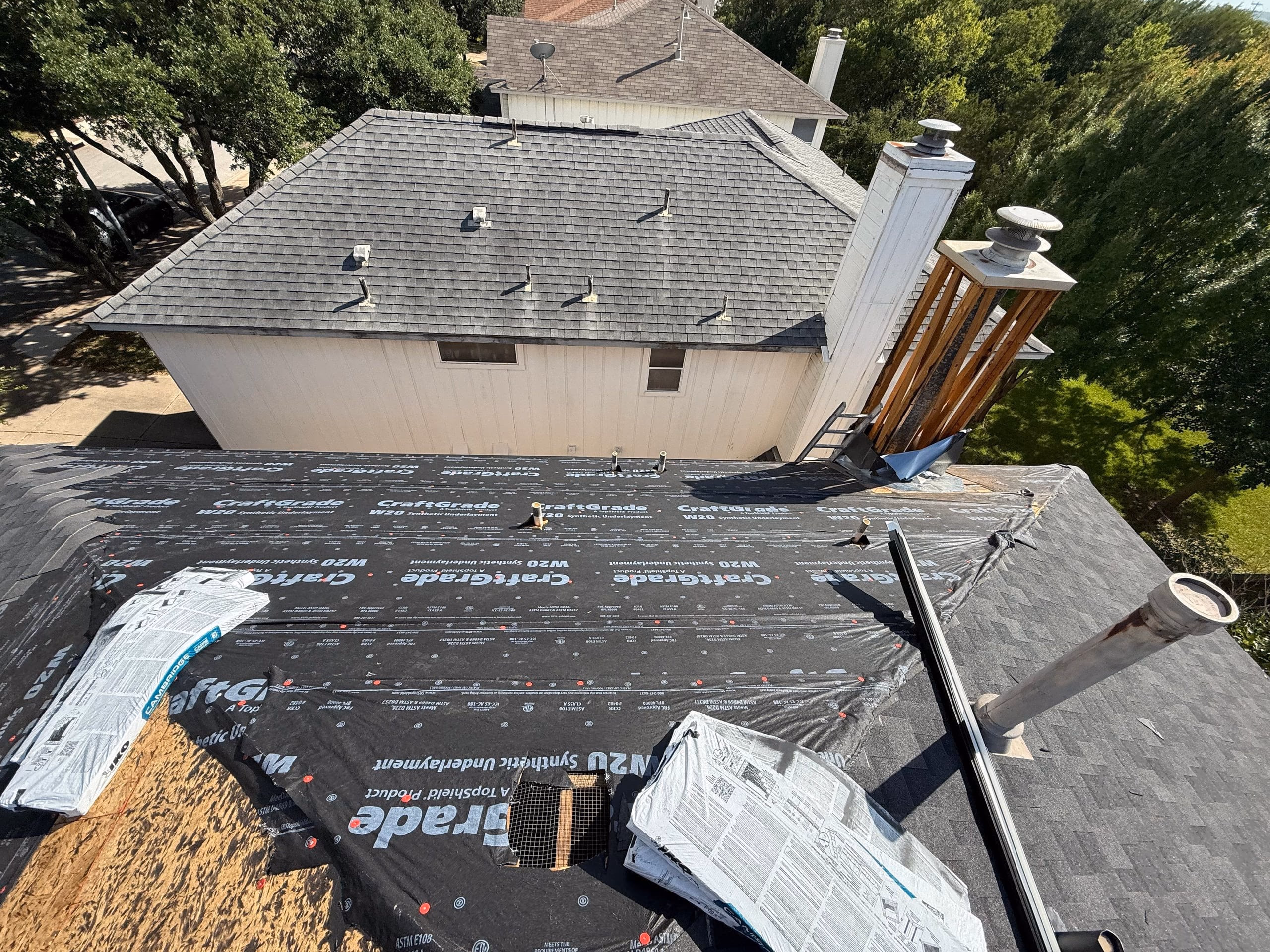 Printed synthetic underlayment installed across a full roof deck before shingles during an Austin, TX roof replacement